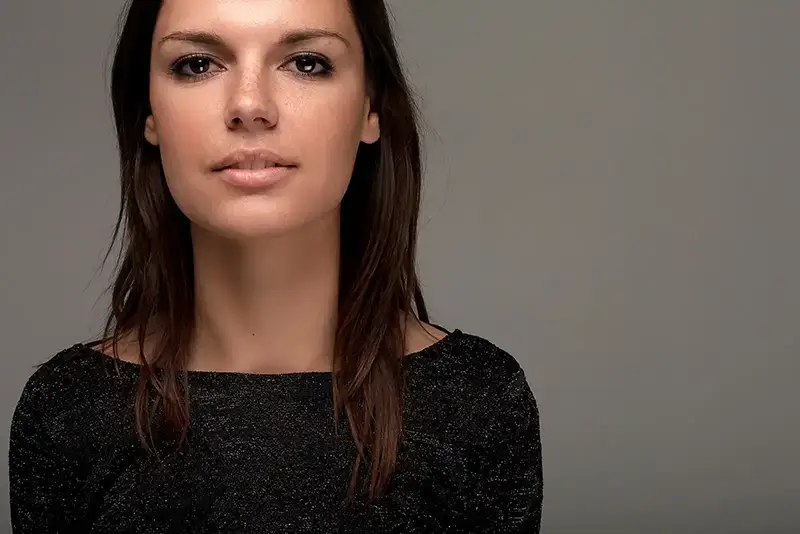 Photographe book mannequin : portrait studio d'une femme sur fond gris